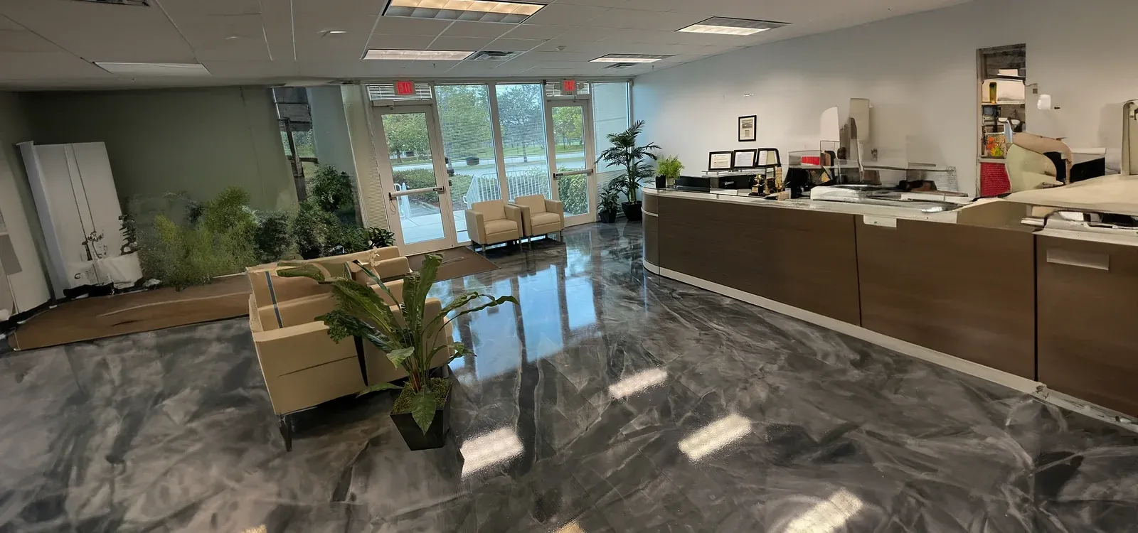 Salón comercial en Miami con piso de epoxi negro espejo de alto brillo y columnas estructurales blancas